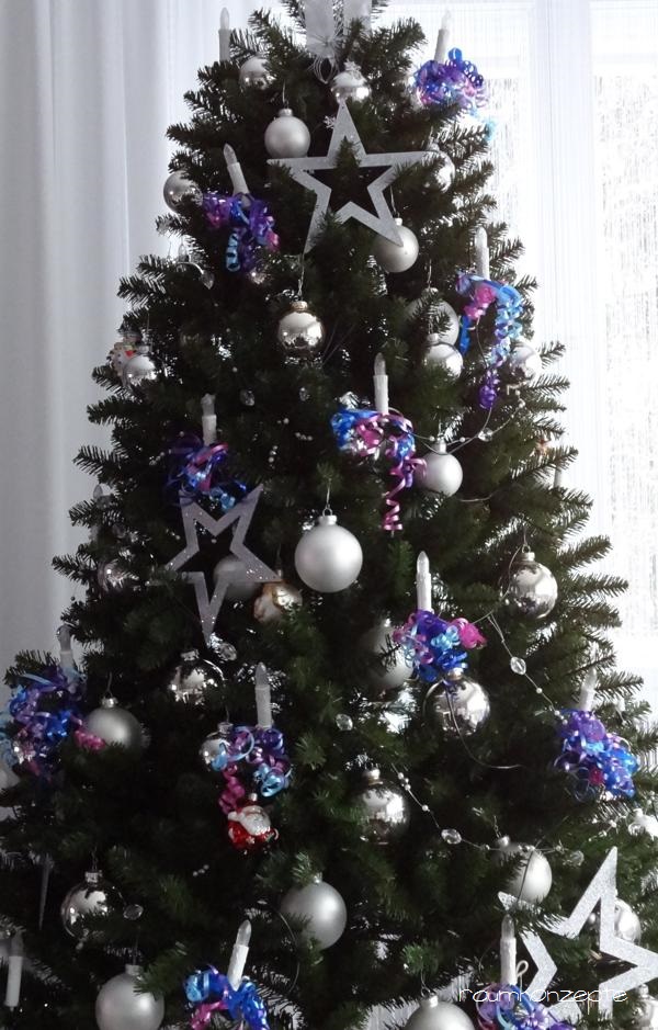 Weihnachtsbaum mit Silberschmuck und lila Baendern