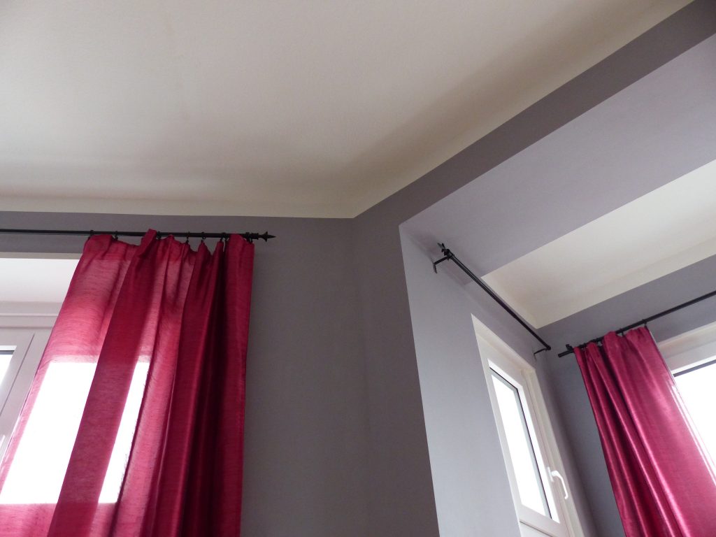 Wohnzimmer Blick 1 nachher mit weisser Decke, grauer Wand und pinkfarbenen Vorhaengen