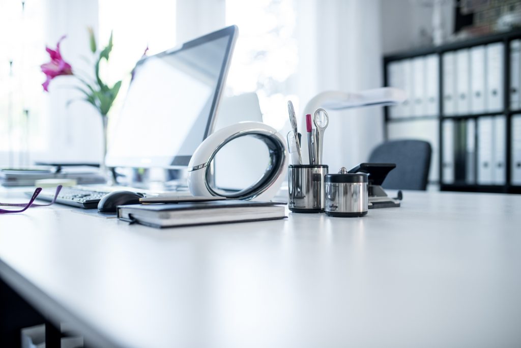 Ein Arbeitszimmer in Pink mit Büroutensilien auf weißem Arbeitstisch