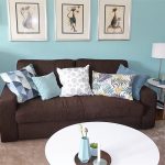 Internet-Wohnzimmer-nachher mit braunem Sofa, drei Bildern vor grüner Wand