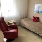 Arbeits-Schlafraum Blick 4 nachher mit Drehsessel, Tisch, Bett und TV als Wandbild