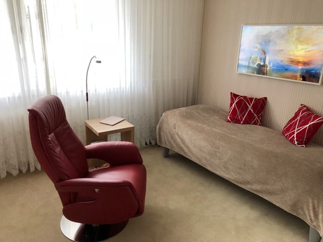 Arbeits-Schlafraum Blick 4 nachher mit Drehsessel, Tisch, Bett und TV als Wandbild