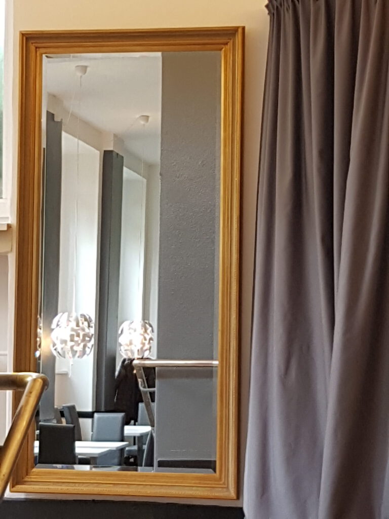 Aula Eingang Vorhang Spiegel nachher in goldfarbigem Rahmen