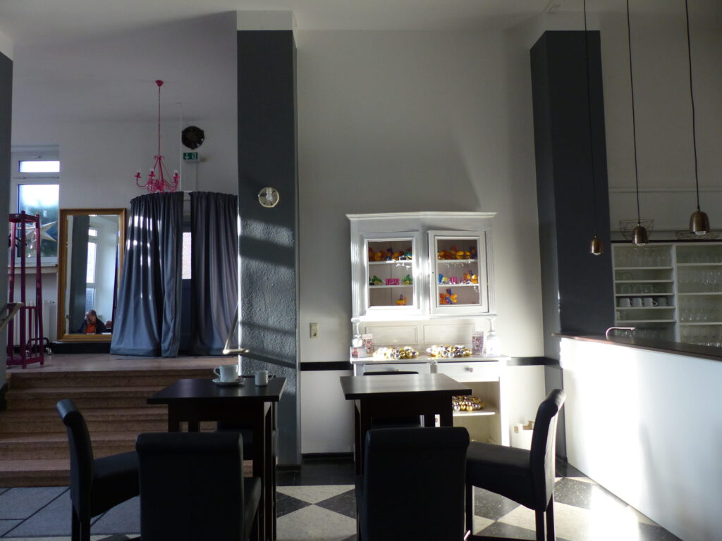 Aula Eingang nachher mit Bistro-Tresen und Tischen