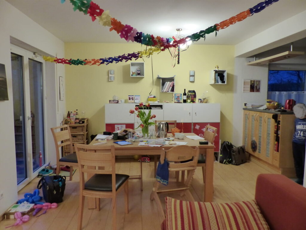 altes Klavier vor Umgestaltung mit Essplatz und schmalem Highboard vor gelber Wand