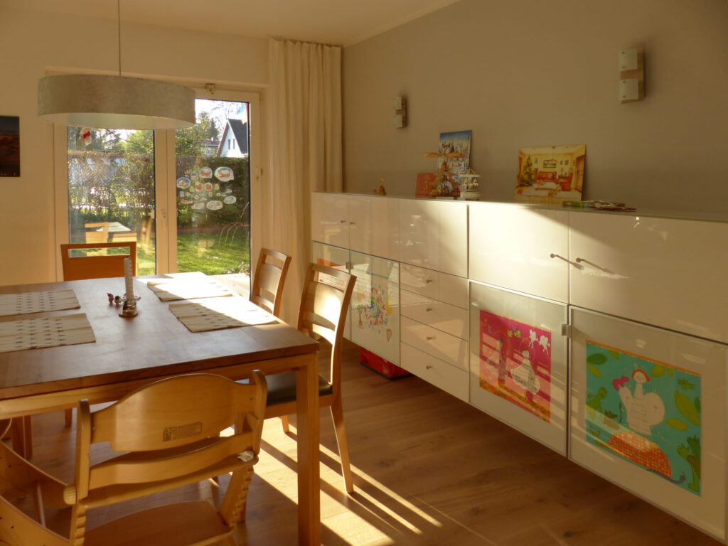 altes Klavier nach Umgestaltung mit Essplatz und breitem Highboard vor grauer Wand