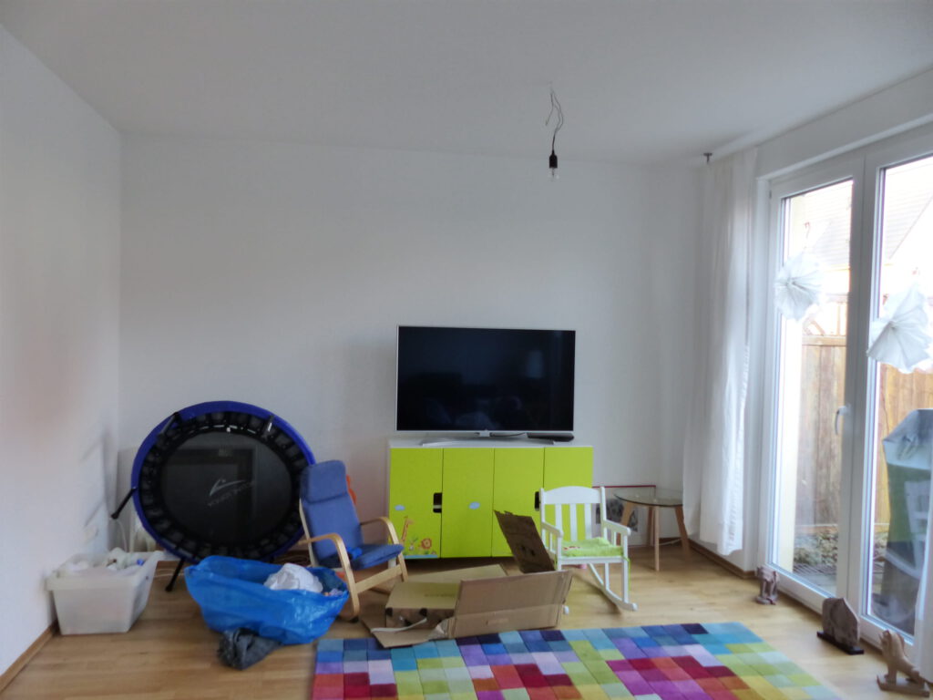 angezogenes Wohnzimmer vor der Umgestaltung mit unklarer Möblierung