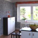 Eingangsbereich links nach Umgestaltung mit grau gemusterter Wand und Kommode