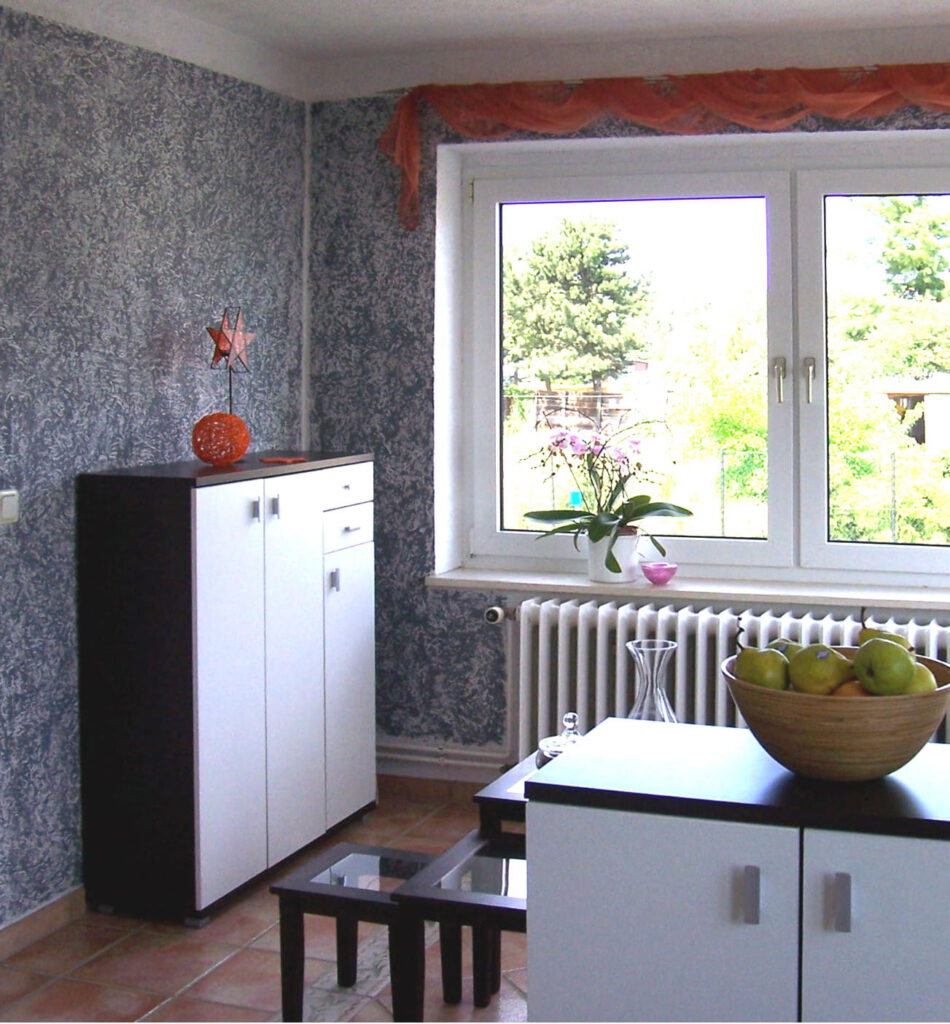 Eingangsbereich links nach Umgestaltung mit grau gemusterter Wand und Kommode