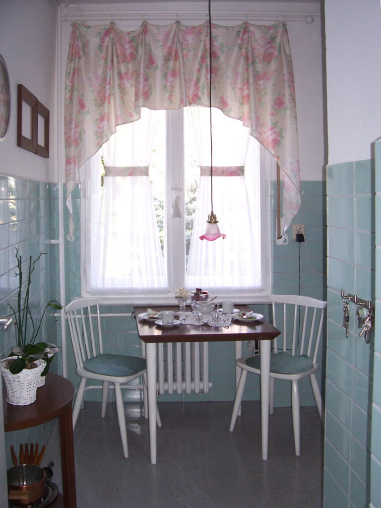 Fenster Kueche mit Scheibengardinen und Querbehang