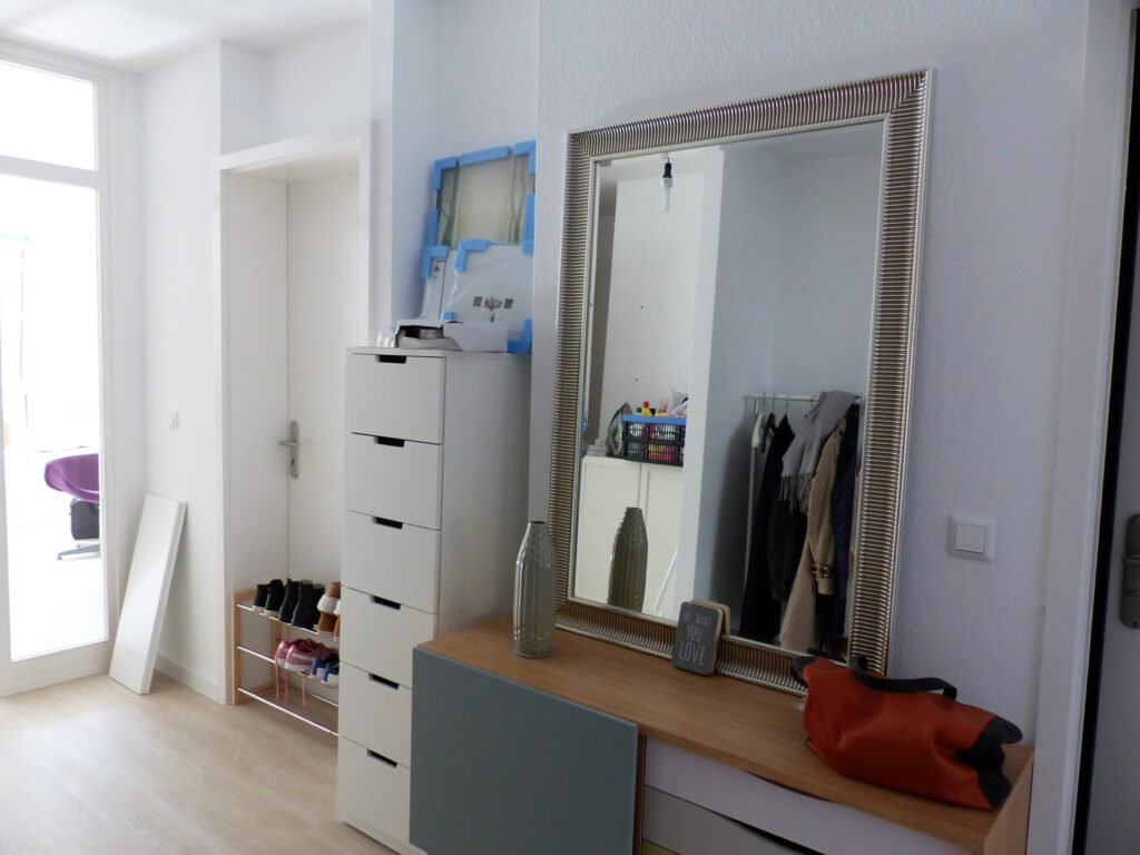 Flur Blick 1 vorher mit Wohnzimmertuer, Schuhablage in Tuer, Schubladenelement, Sideboard und Spiegel