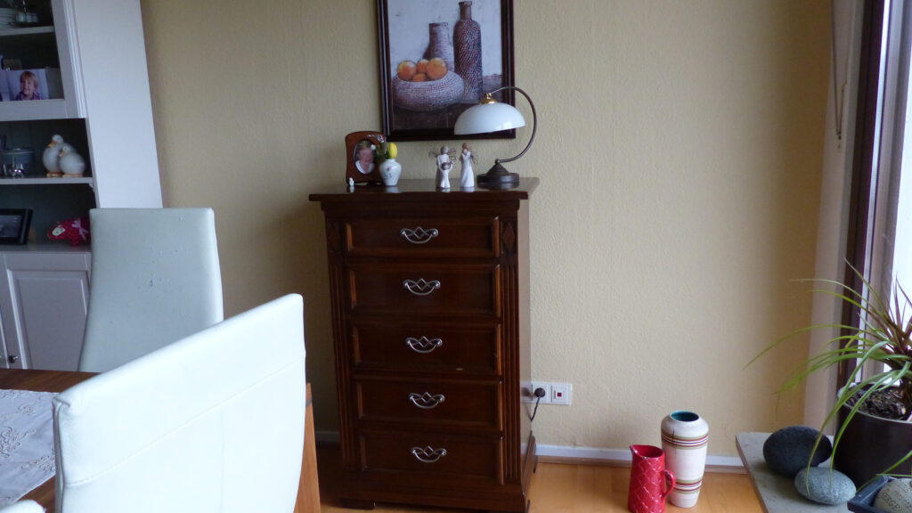 Internet-Wohnzimmer-vorher mit brauner Kommode vor brauner Wand