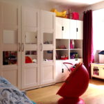 Kinderzimmer links nach Umgestaltung aufraeumbar mit großen weissen Schraenken und neuen Vorhaengen