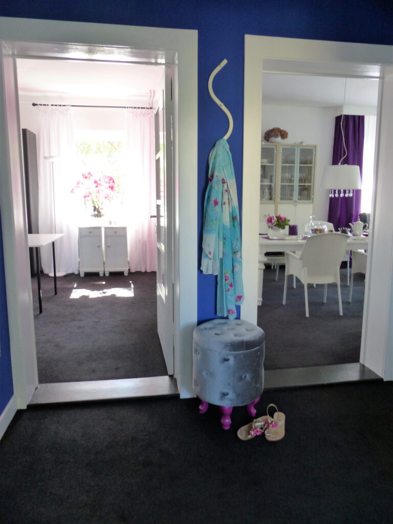 kleiner blauer Innen-Flur mit Blick in Wohnräume