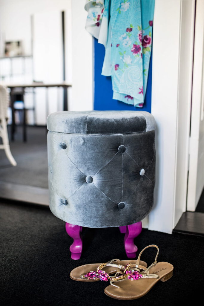 kleiner blauer Innen-Flur mit Samthocker auf pinken Holzfüßen