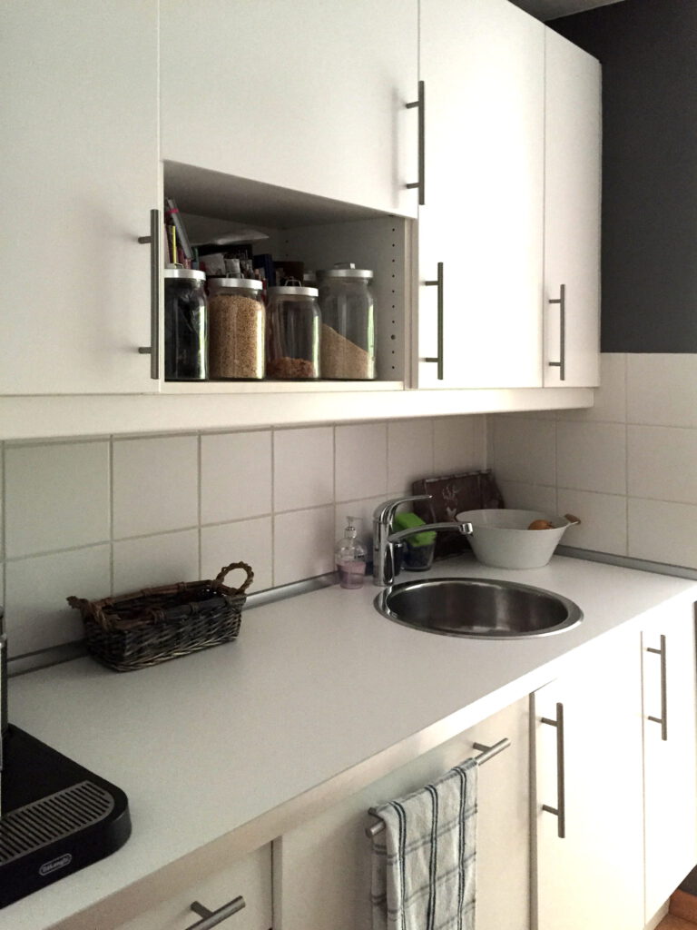 Kueche nach Umgestaltung mit weisser Arbeitsplatte und ausreichend Arbeitsflaeche