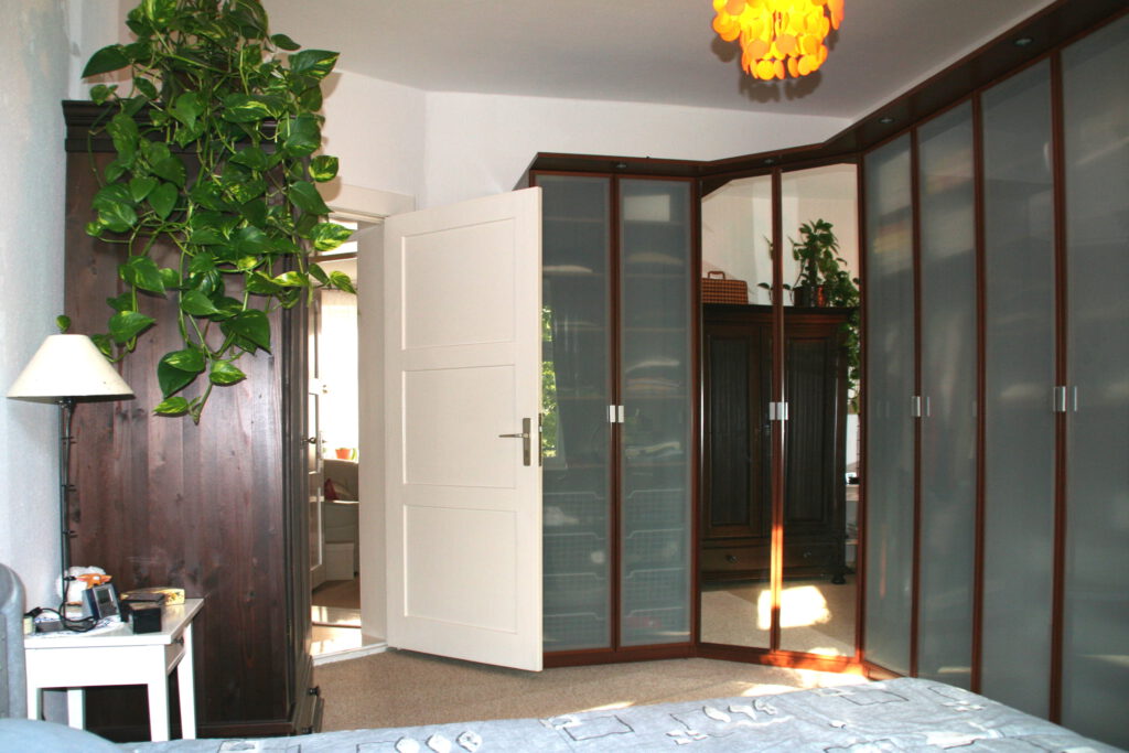 Schlafzimmer Moebel Ecke links nach Umgestaltung mit modernem Kleiderschrank-System ueber Eck