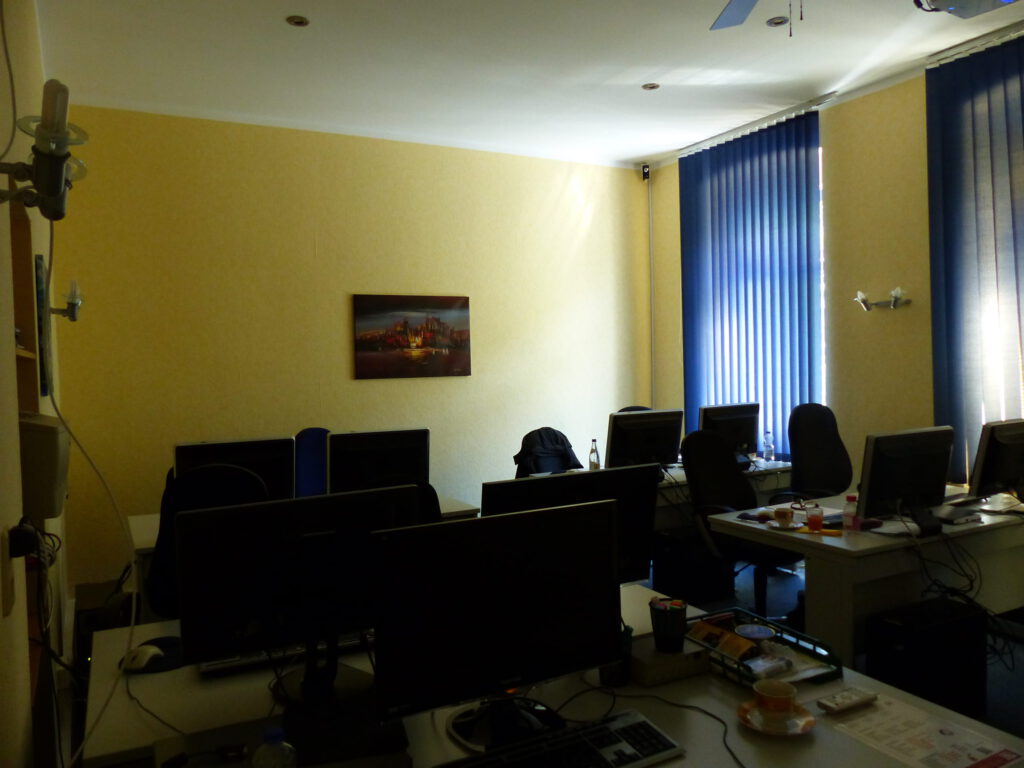 Schulungsraum vor Umgestaltung Rückseite mit gelber Wand und Wandbild