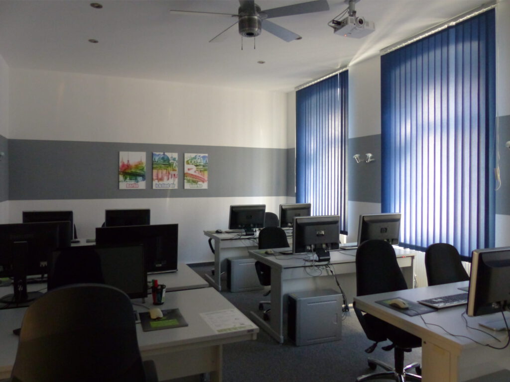 Schulungsraum nach Umgestaltung Rückseite mit weißer Wand und grauem Farbstreifen