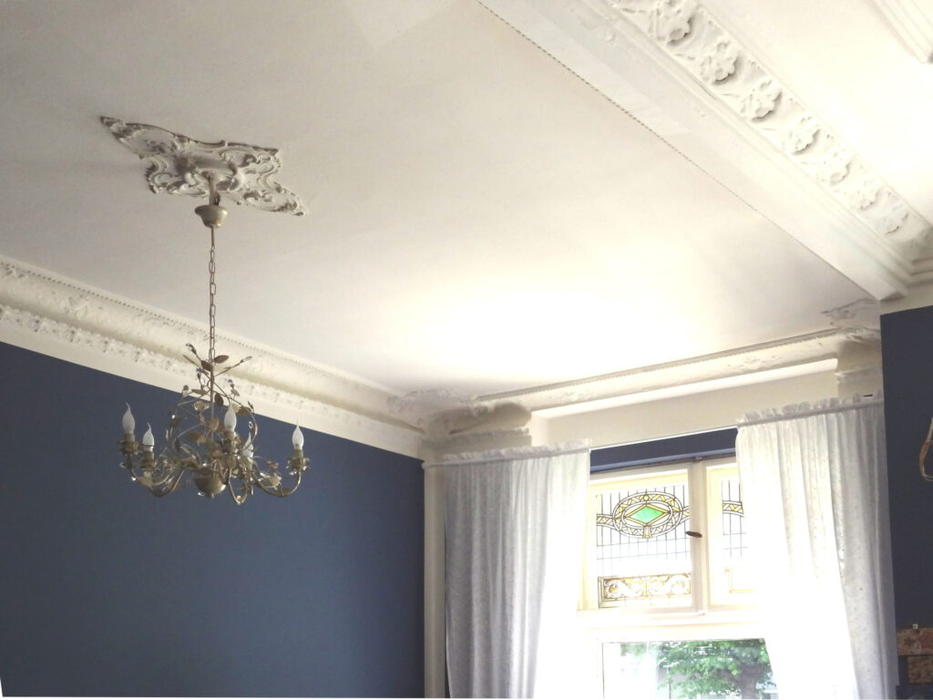 Shop Fensterbereich nach Umgestaltung mit taubenblauer Wand-Farbe und weissen Vorhaengen