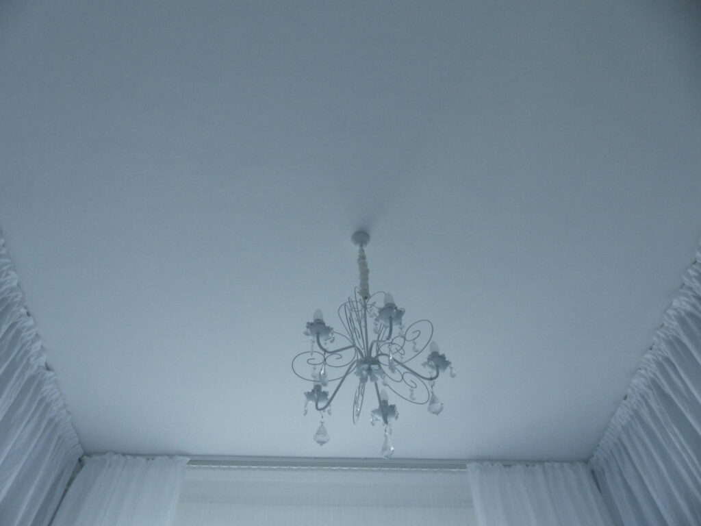 weisses Schlafzimmer Fertig mit Kronleuchter, Decke und Vorhänge in weiß