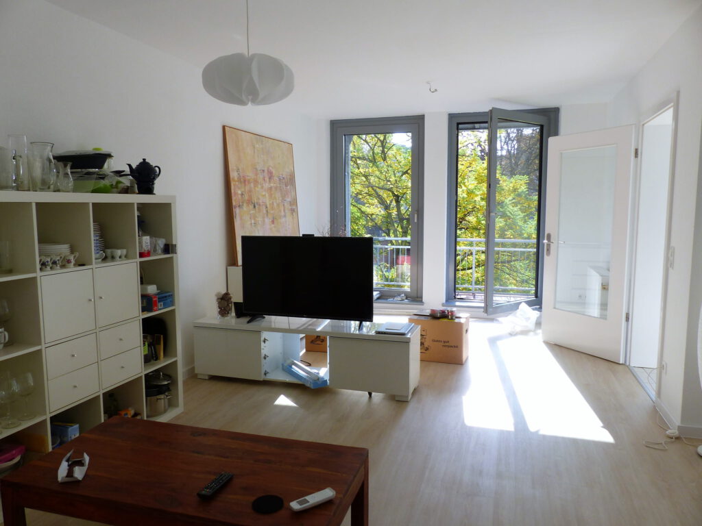 Wohnbereich Blick 5 vorher mit Couchtisch, Regal, TV und Balkonfenster