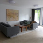 Wohnbereich Blick 6 nachher mit Zweisitzer, Couchtisch, Wandbild, Teppich und Stehlampe