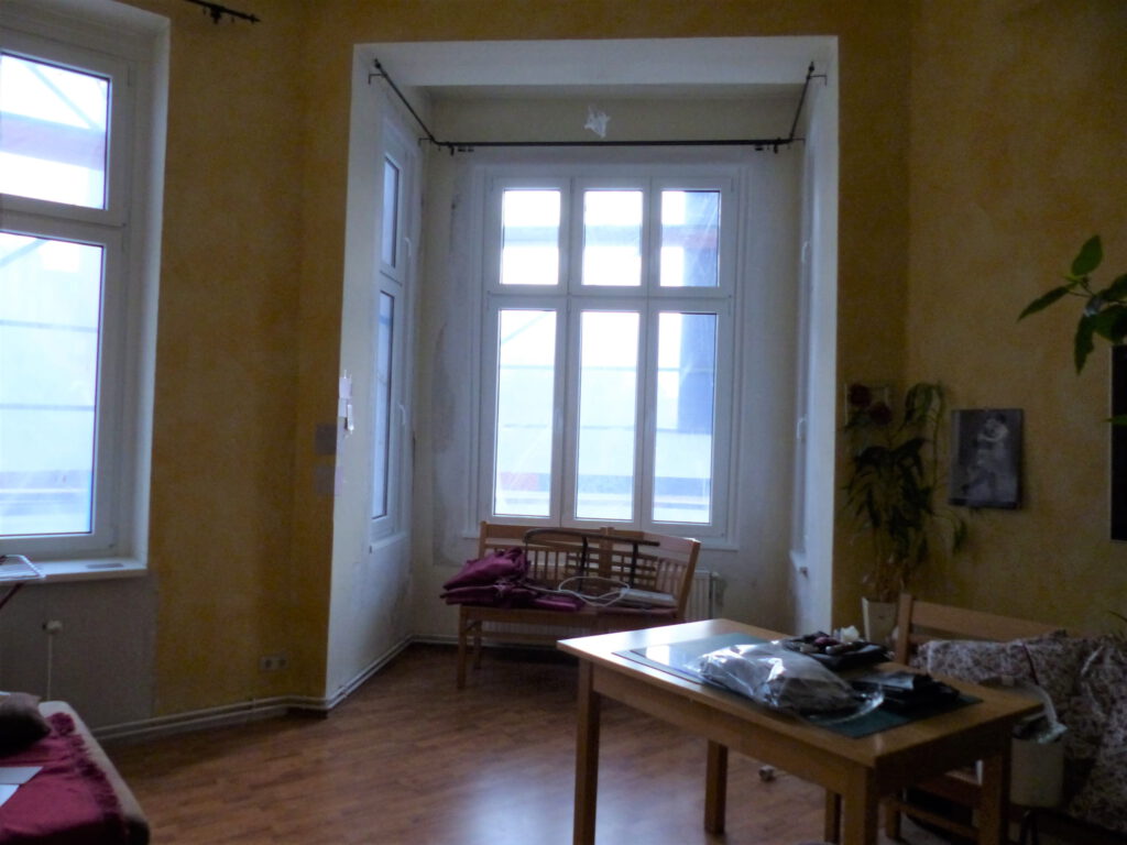 Wohnzimmer Blick 1 vorher mit Erker, Esstisch und gelber Wand