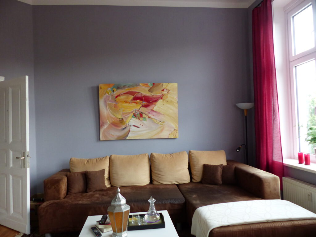 Wohnzimmer Blick 5 nachher mit Couchtisch, Ecksofa und Wandbild vor grauer Wand